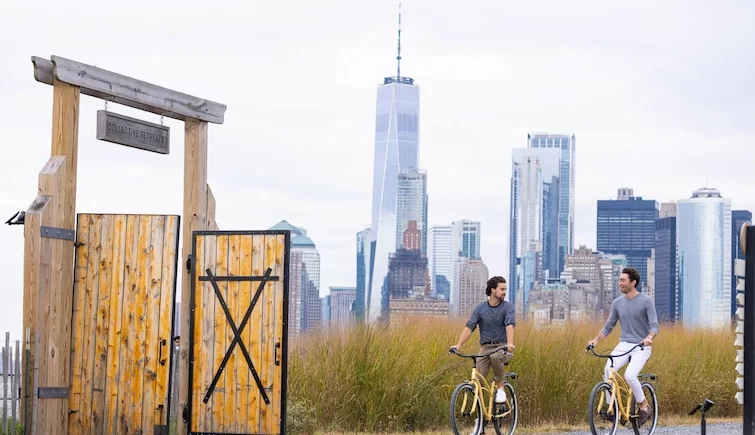 Two man riding bike with the city view